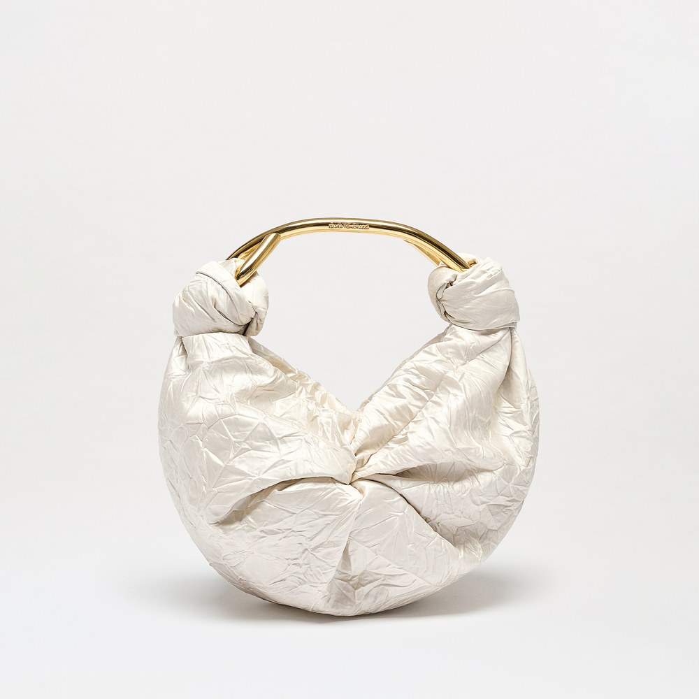 The Sofia Bag (Small) is a white bag with a crinkled texture, made from Italian fabric. It features a round gold-toned handle and knot details on both sides, shown against a plain white background.
