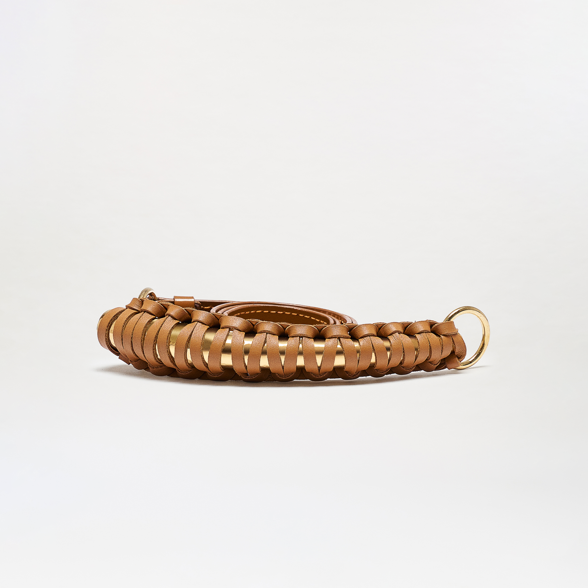 The Ife Belt is a coiled brown leather belt with a woven design and gold metal buckle, shown on a plain white background.
