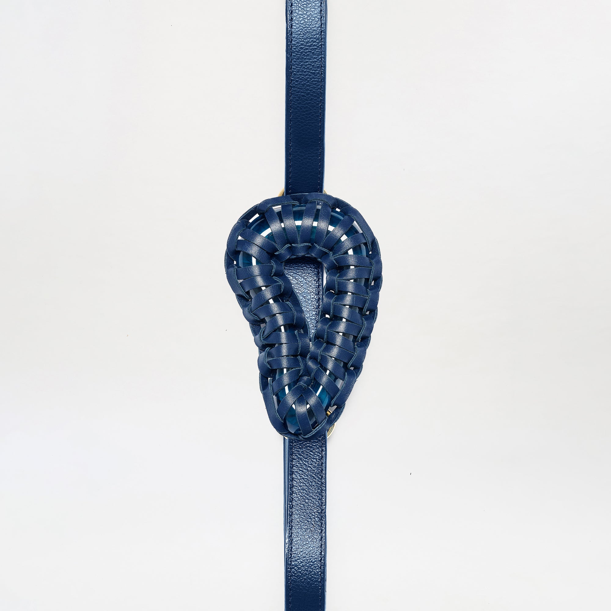 The Renata Belt is a blue leather strap featuring a woven, ear-shaped blue leather centerpiece, shown vertically against a plain white background.