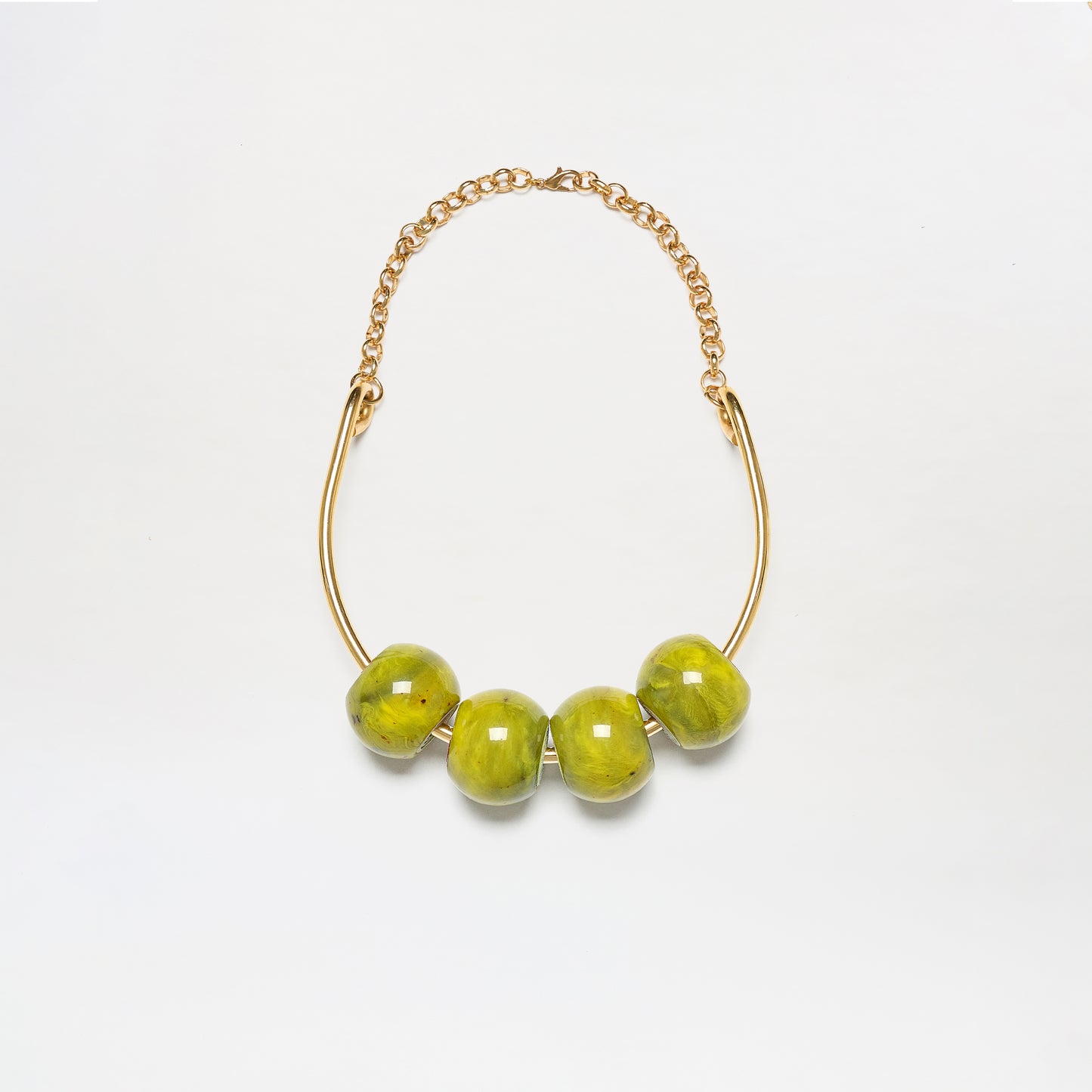 The Martini Chocker is a gold chain necklace featuring four large, glossy green beads on a curved gold bar, shown against a white background.