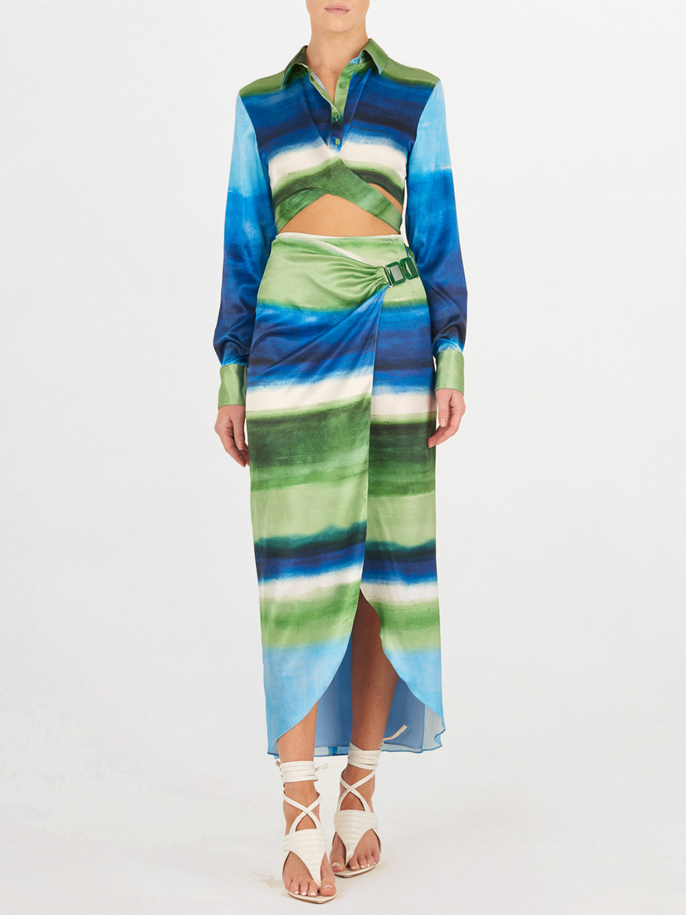 A long skirt with a tie-dye pattern in shades of blue and green, featuring a wrap design and a belt buckle detail at the waist. The Adrianne Skirt Washed Emerald Blue is final sale and not eligible for return.