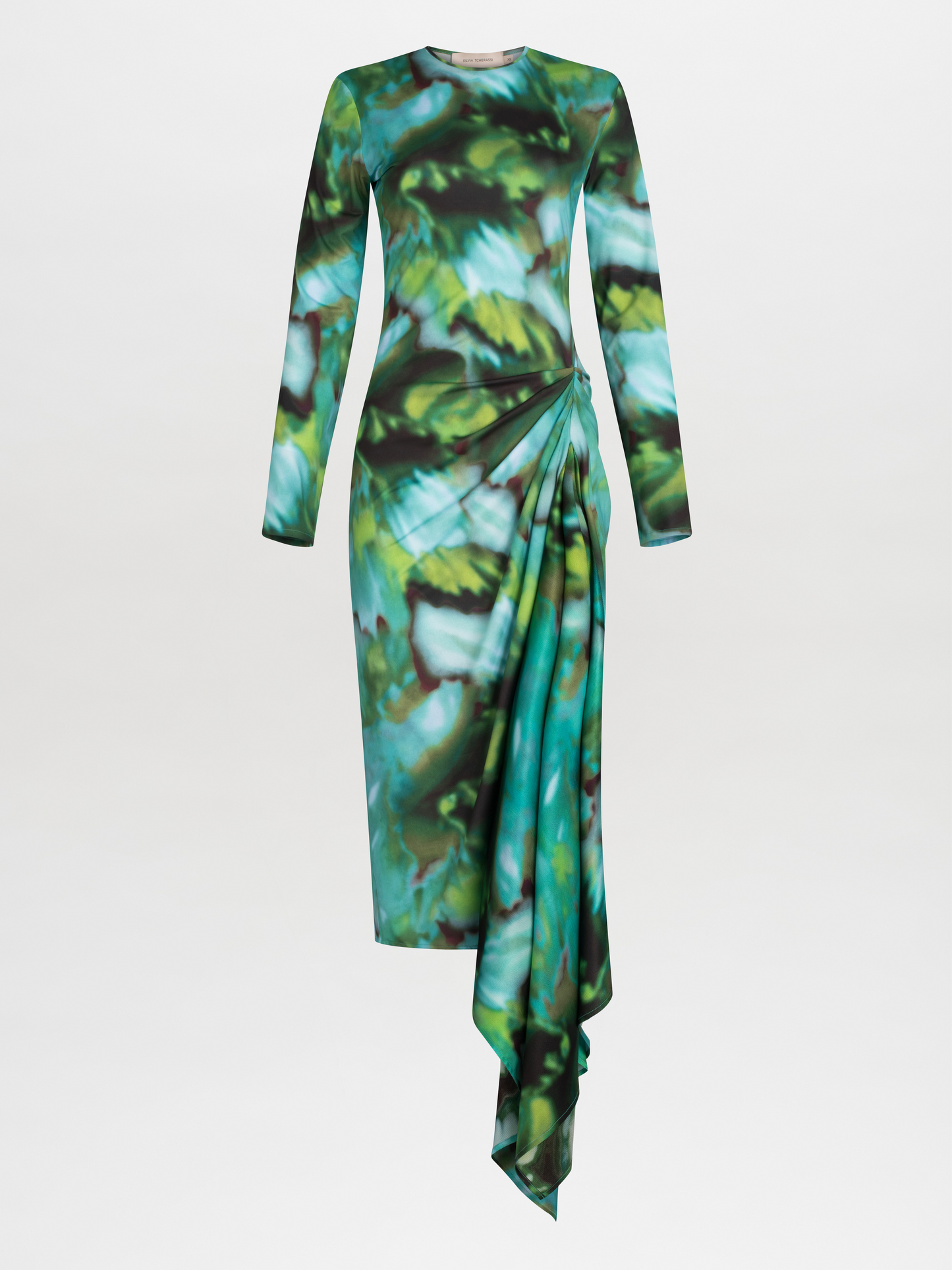 Ananya Dress Juniper Green with a green and blue abstract leaf pattern and asymmetrically draped skirt, isolated on a white background.