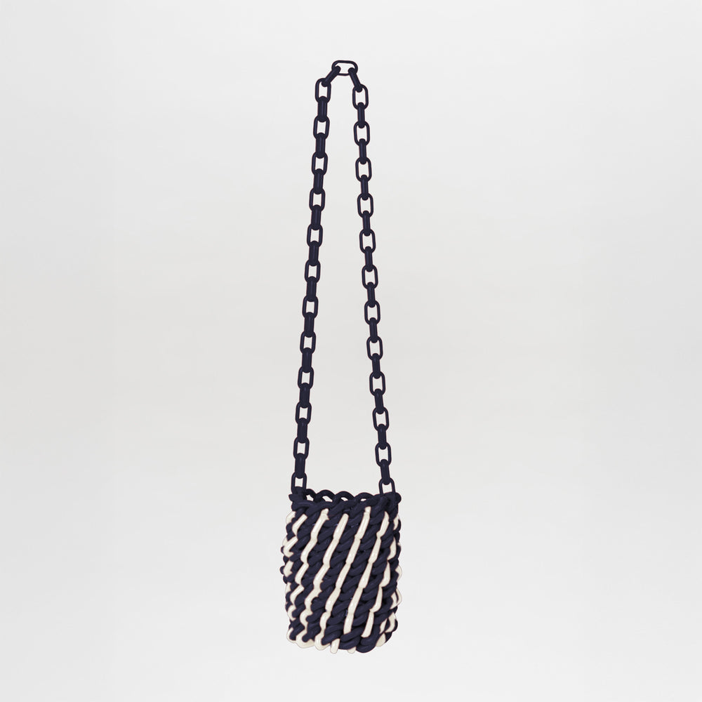 The Anise Bag Navy White is a small cylindrical bag with a chunky chain strap, twisted navy-and-white rope design, and unique resin rings, set against a plain background.