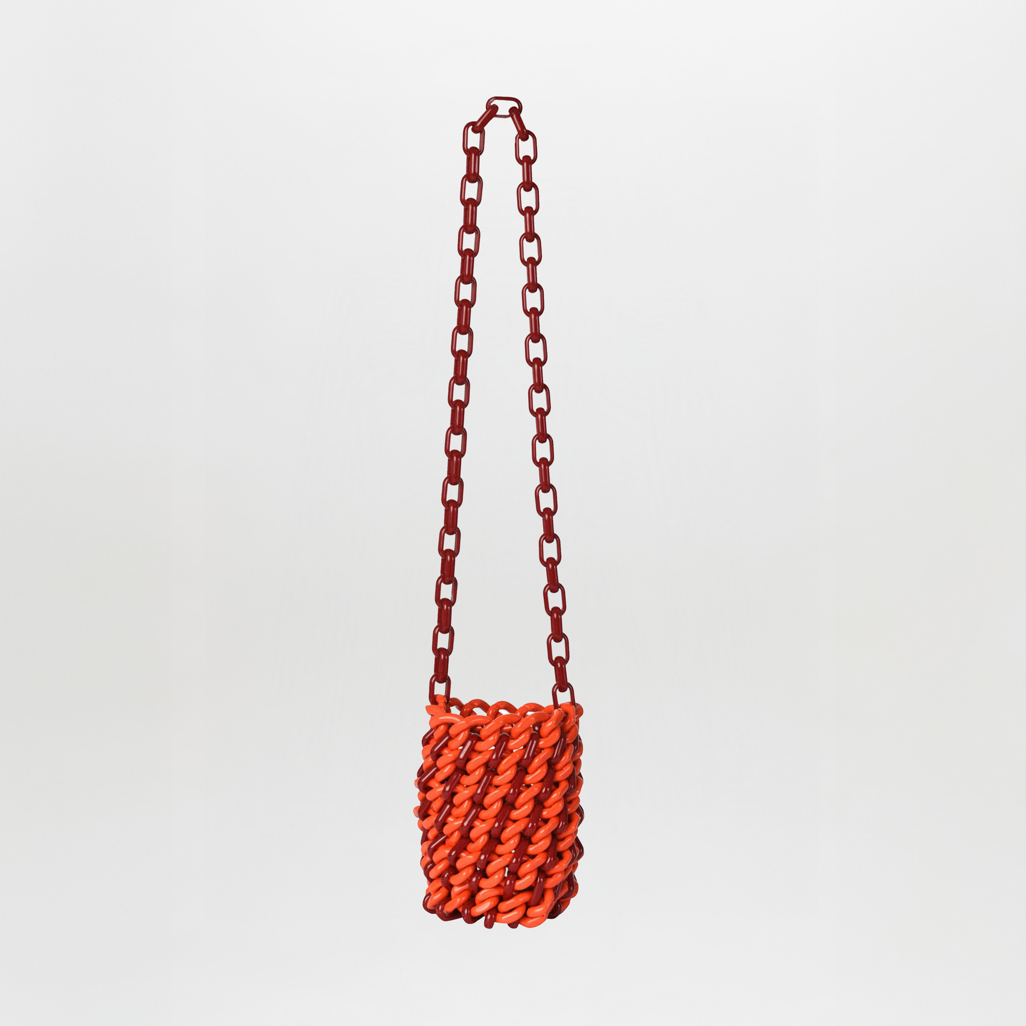 The Anise Bag Red / Burgundy is a small crossbody handbag with a chunky red resin ring chain strap and an orange woven body, shown against a plain white background.