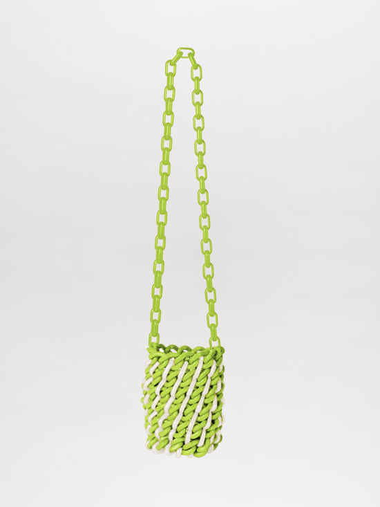 The Anise Bag Lime White is a small handbag in lime and white, featuring an elongated chain strap with subtle resin rings, all set against a plain white background.