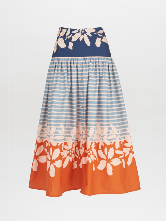 The Apia Skirt Celeste Orange is a flared midi design that features horizontal blue stripes and a wide blue and white floral band at the top. The hem is embellished with an eye-catching celeste orange floral border.