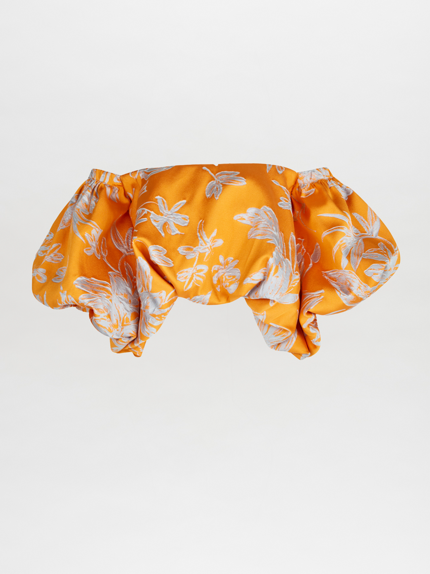 The Arezzo Blouse Apricot Silver showcases a charming orange off-the-shoulder design with a white floral pattern and voluminous sleeves, exuding polished elegance against a plain background.