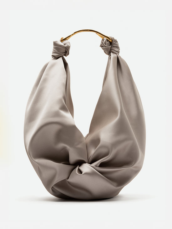 A beige fabric Sofia Bag (Maxi) Beige featuring a twisted knot design and gold metal handles, set to ship by date of November 15th, 2024.