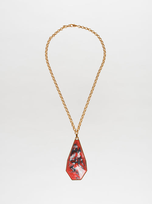 The Ascoli Necklace Rouge features a pendant necklace with a gold-plated brass chain and a teardrop-shaped pendant showcasing an Italian resin marbled design in shades of red, black, and gray.