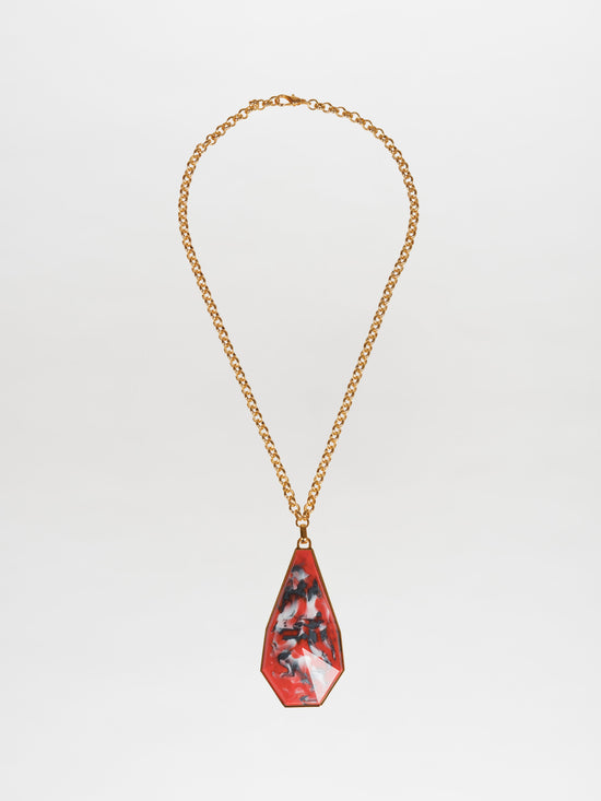 The Ascoli Necklace Rouge features a pendant necklace with a gold-plated brass chain and a teardrop-shaped pendant showcasing an Italian resin marbled design in shades of red, black, and gray.