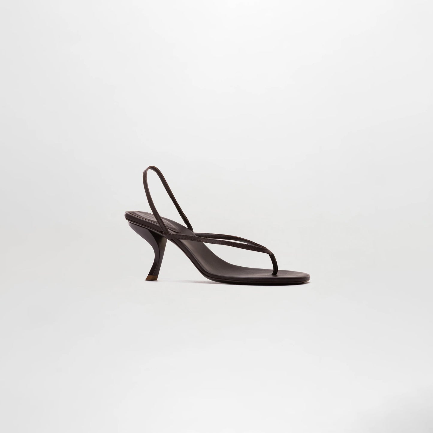 The Aurora Heels, dark brown sandals crafted from Italian leather with thin straps and a curved heel, are showcased against a plain light background.