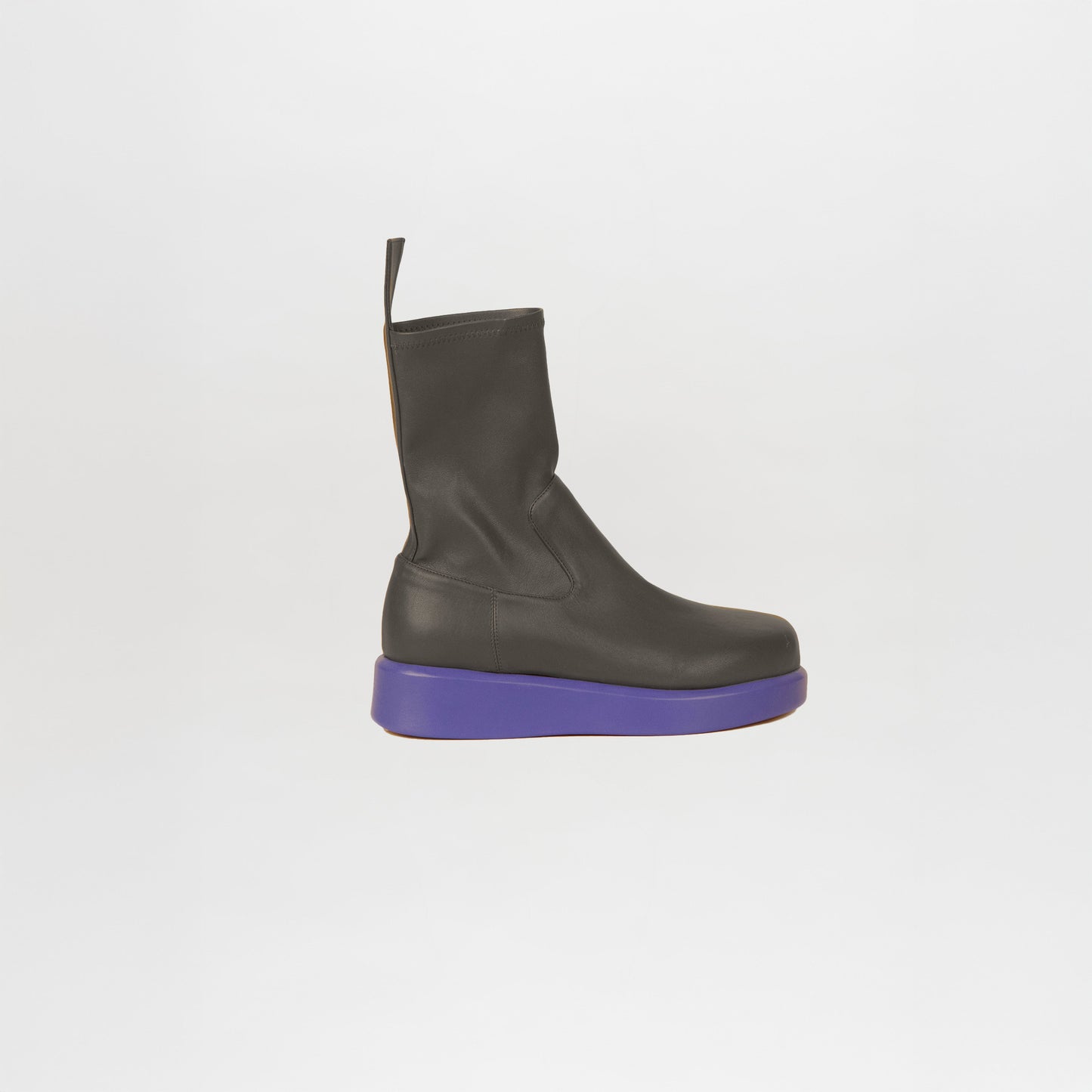 The Baia Boots Black Violet feature soft stretch calf leather in black, a pull tab, and a thick flat purple sole—an iconic Silvia Tcherassi design—shown here in profile against a white background.