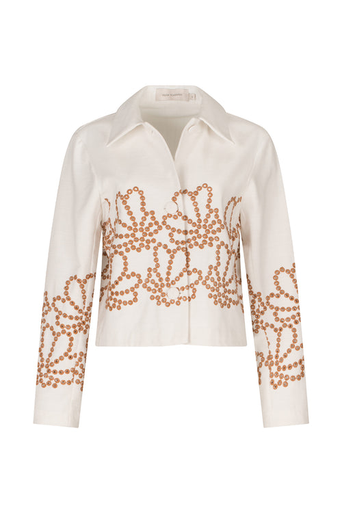 A Belen Jacket White Cacao Eyelet featuring a collared neckline and intricate brown beaded floral patterns on the front and sleeves, complemented by an effortlessly loose silhouette.