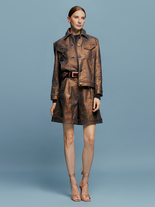 The model is wearing a Bimba Bermuda Metallic Ocher available for pre-order.