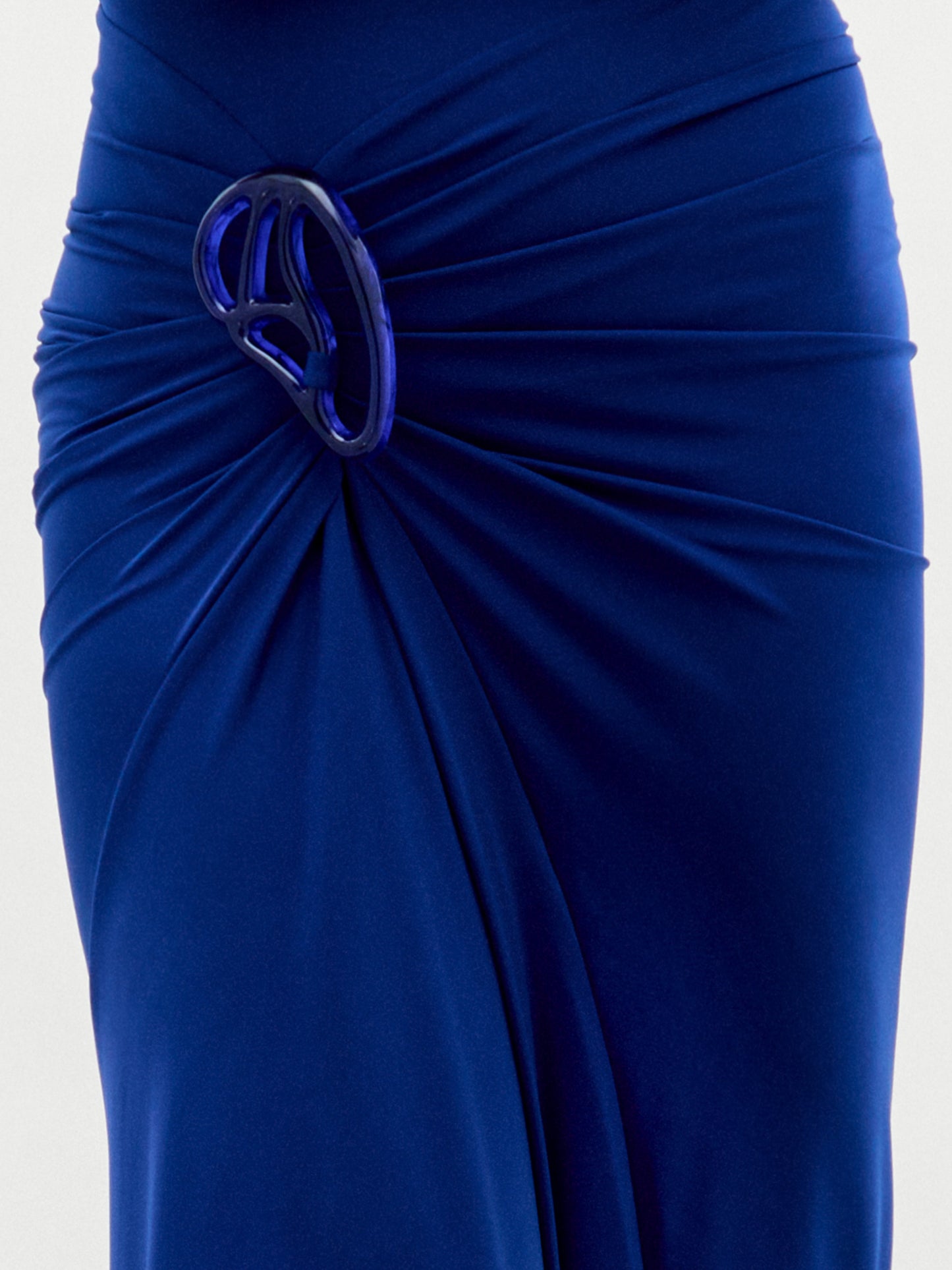 A model wears the Bogna Dress, a sleeveless high-neck blue gown with draped detail, against a plain white background.