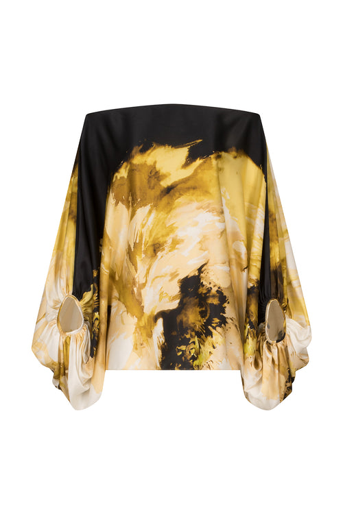 An off-the-shoulder Bellagio Blouse Golden Peony with a black and gold print.