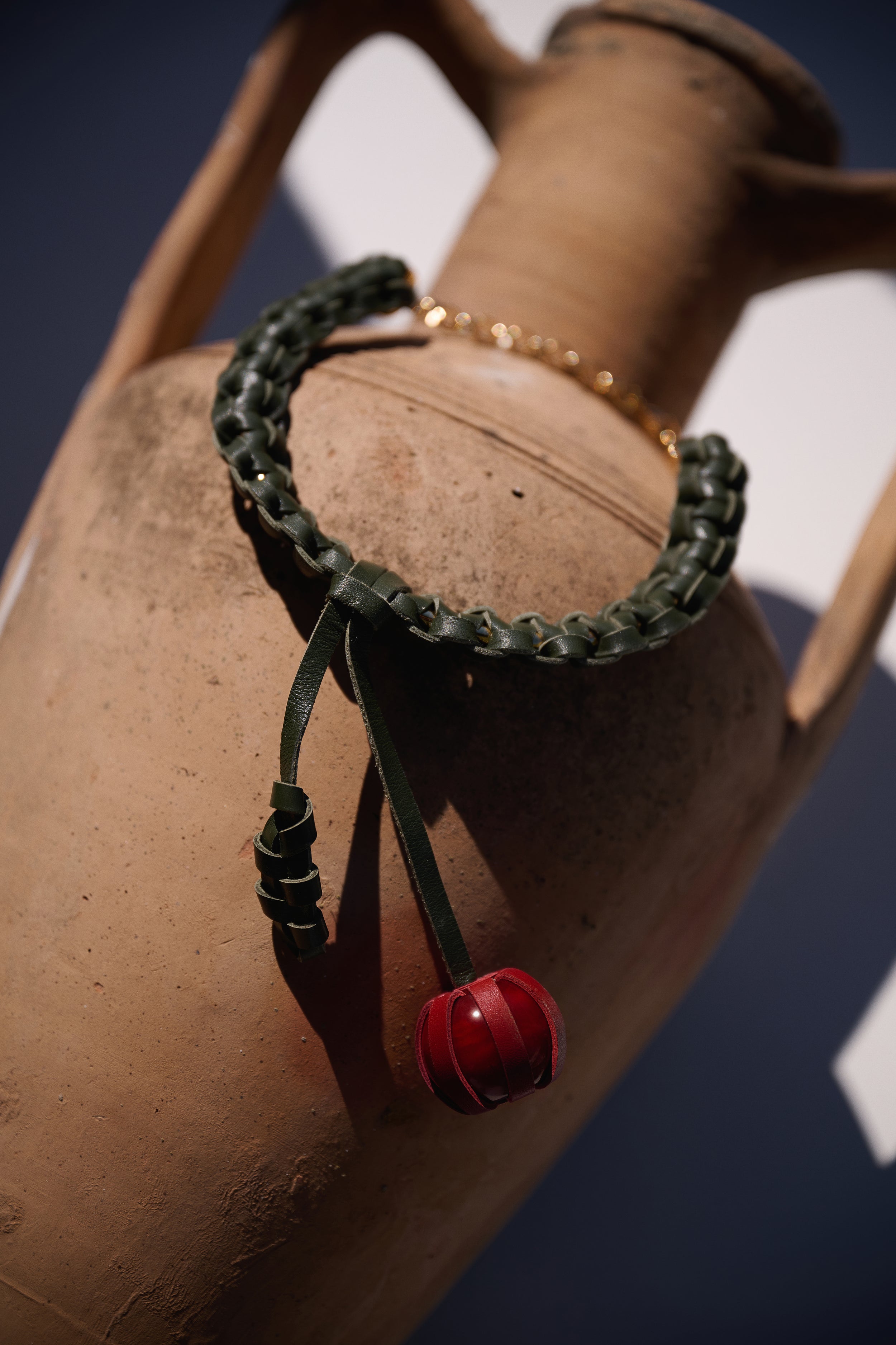 Bracelet with a red charm on a brown surface