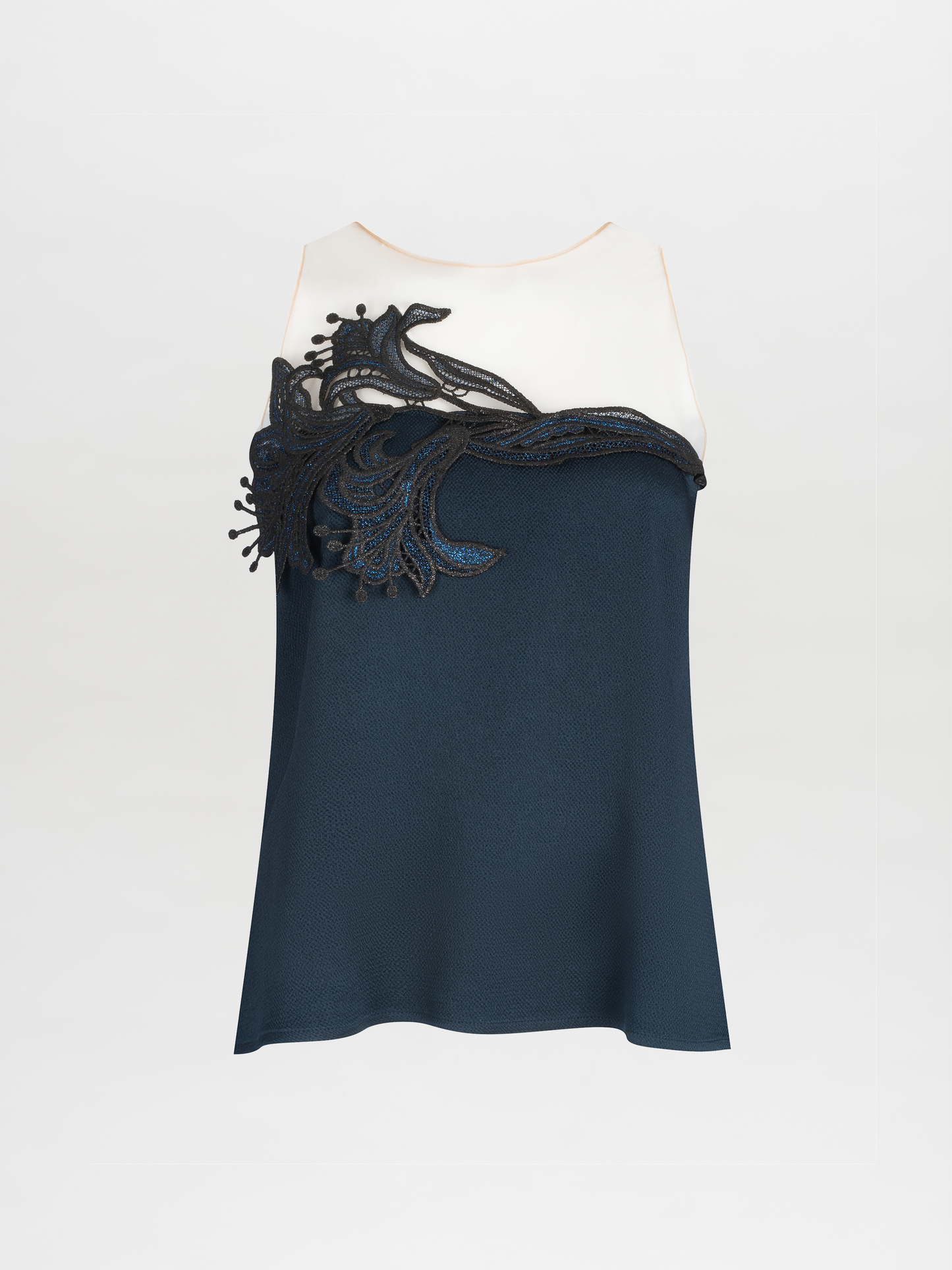 A Brisa Blouse Navy with a white upper and dark blue lower section, featuring intricate guipure lace detailing on the chest.