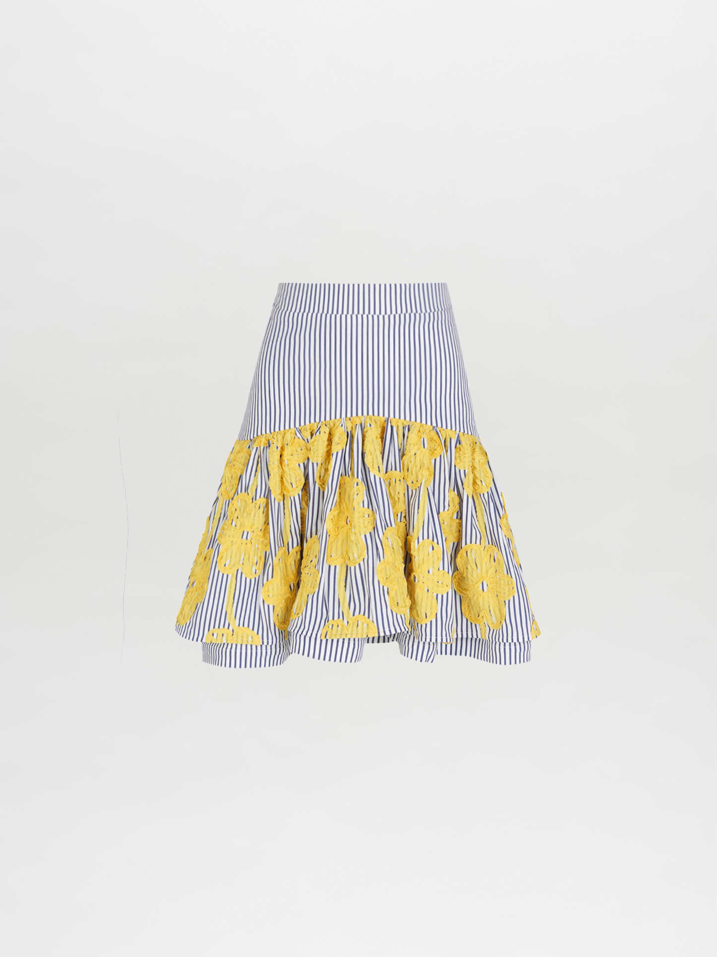 The Buccan Skirt Yellow Embroidered Flowers showcases Silvia Tcherassi's distinctive style with alternating yellow floral crochet patterns on the lower half, set against a plain background.