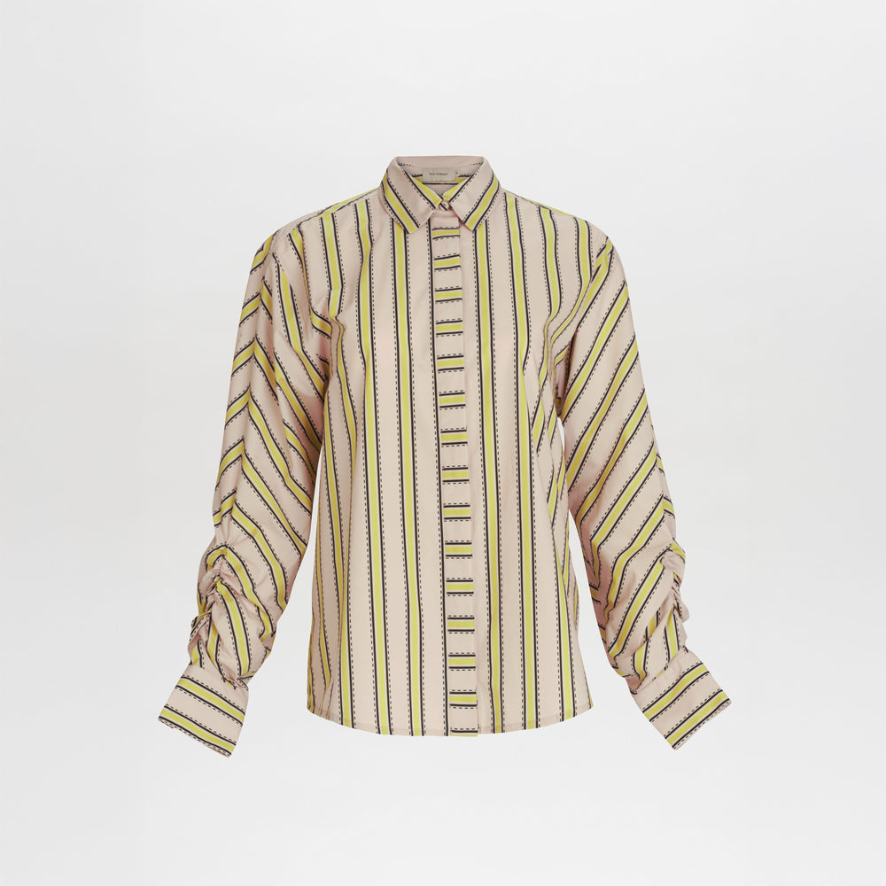 The Caritina Blouse is a long-sleeved, 100% cotton button-up with vertical yellow, black, and green stripes on beige, ruched sleeves, and a classic shirt collar.