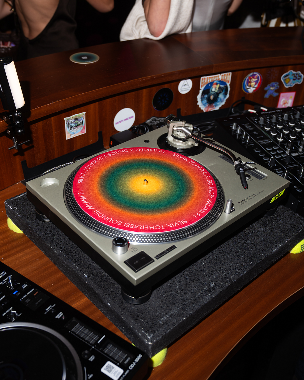 Turntable with a colorful platter on a wooden turntable stand.