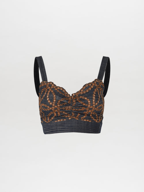 The Candance Top Chambray Embroidery is a black sleeveless crop top featuring intricate gold sequined designs and adjustable straps, accented with delicate floral motifs.