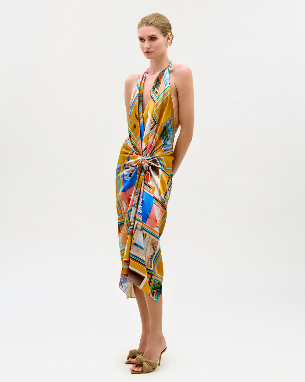 Model wearing a colorful dress with abstract Cartagena-inspired graphics on a white background