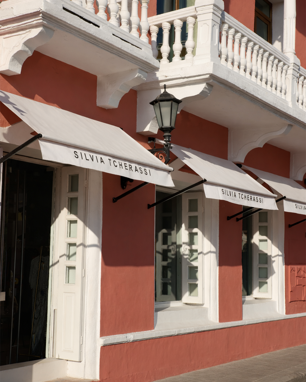 Red building facade with white awnings displaying 'Silvia Tcherassi' branding.