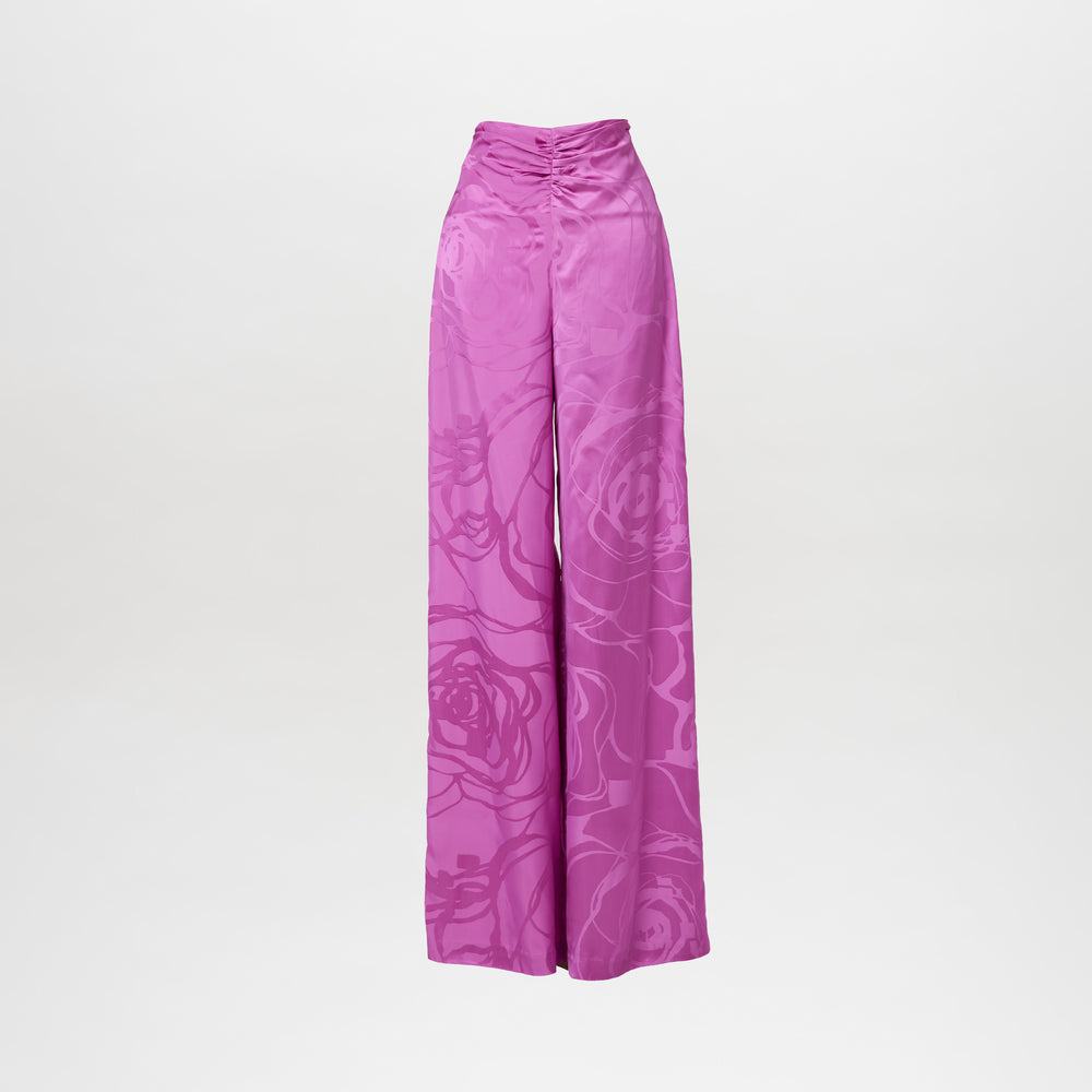 The Casey Pant Magenta Orchid Jacquard features high-waisted, wide-leg pants in magenta jacquard with a subtle floral pattern and delicate ruching at the waistband, shown against a plain white background.