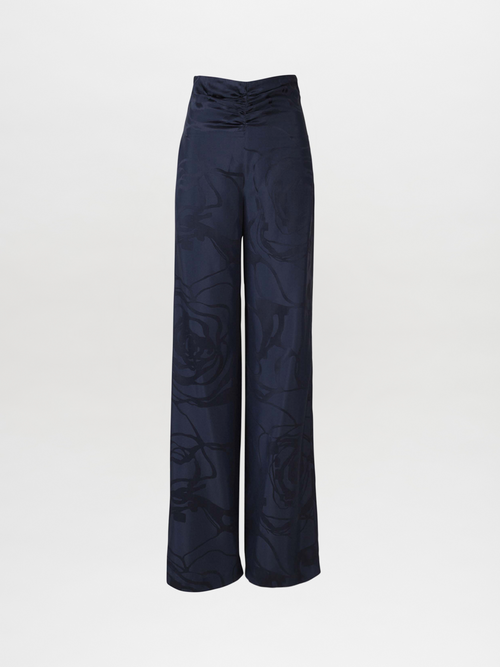 Casey Pant Navy Jacquard, these high-waisted, wide-leg pants featuring a subtle floral pattern in luxurious jacquard fabric and a gathered waistband detail.