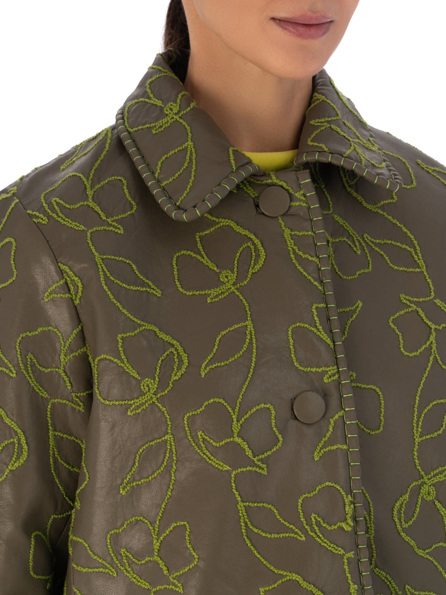 Explore the Columba Jacket in Forest Green, crafted from embroidered ecoleather. It showcases lime green floral embroidery, a chic collar, a button-down front, and long sleeves for an elegant mix of classic style with striking embroidery.