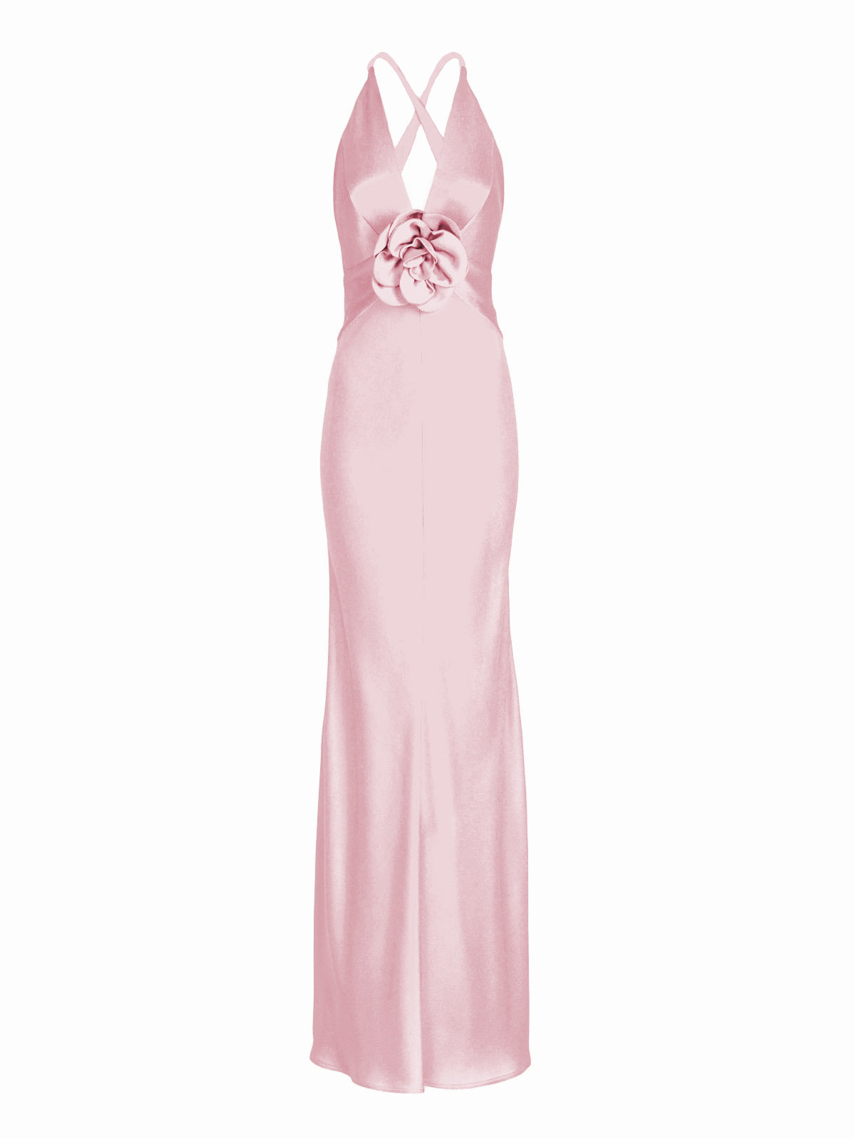 A person stands facing forward wearing the Daniela Dress Pink—a long, pastel pink dress featuring a halter neck and a large rose embellishment at the front. The background is plain white. Available for pre-order now, the dress will ship by February 1st, 2025.