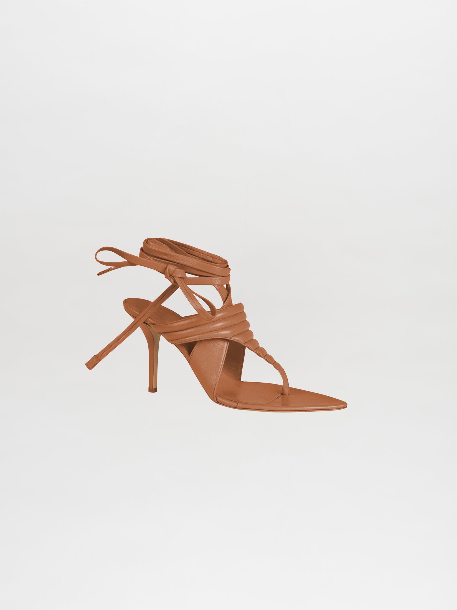 The Dalila Heels Camel showcase a brown strappy high-heeled sandal design, meticulously crafted from Italian calf leather. Featuring a pointed toe and an ankle wrap, they are elegantly set against a plain white background.