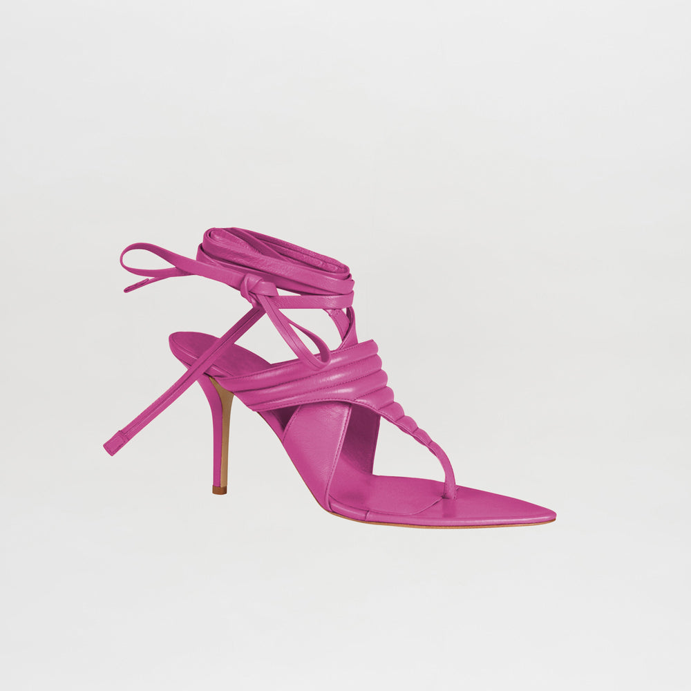 A single Dalila Heels Magenta, crafted from Italian calf leather with a strappy design and ankle wrap ties, is displayed against a plain white background.