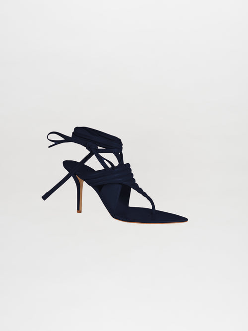 The navy Dalila heels showcase sophisticated ankle straps and an open toe design, crafted from luxurious Italian calf leather, set against a pristine white background.