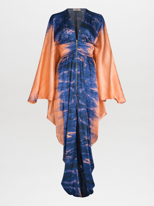 A long, flowing Danette Dress Mediterranean Coral Blue with blue and orange tie-dye patterns, displayed against a white background.