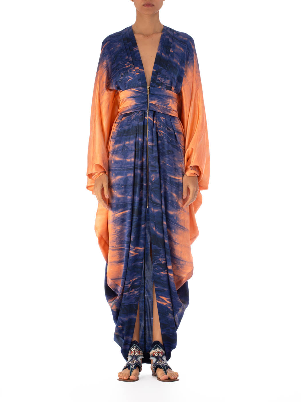 A long, flowing Danette Dress Mediterranean Coral Blue with blue and orange tie-dye patterns, displayed against a white background.