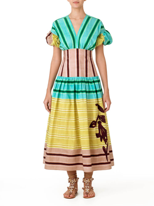 A Darice Dress Meadow View with puffed sleeves and a multicolor stripe pattern in shades of green, pink, and beige, featuring a floral design on the lower part, isolated on a white background.