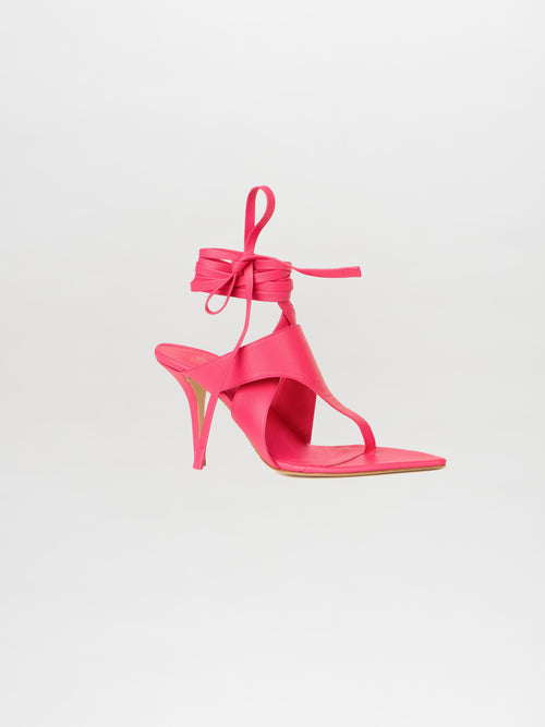 A single Domenico Heels Fucsia, featuring ankle straps and crafted from luxurious Italian leather, stands elegantly against a plain white background.