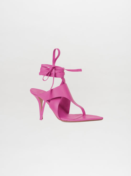 The Domenico Heels Magenta, crafted from luxurious Italian leather, stand out against a plain white background with their elegant pink design and ankle wrap straps. These high-heeled sandals perfectly embody the GIA Couture style and are a testament to exquisite craftsmanship.