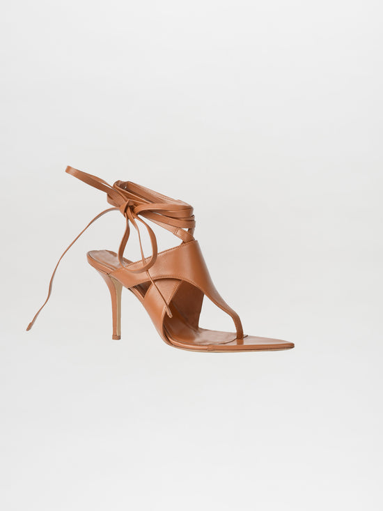 The Domenico Heels Camel, a single high-heeled sandal made from Italian leather with sophisticated ankle wrap straps, showcased on a plain white background, embodies the luxurious style of GIA Couture.