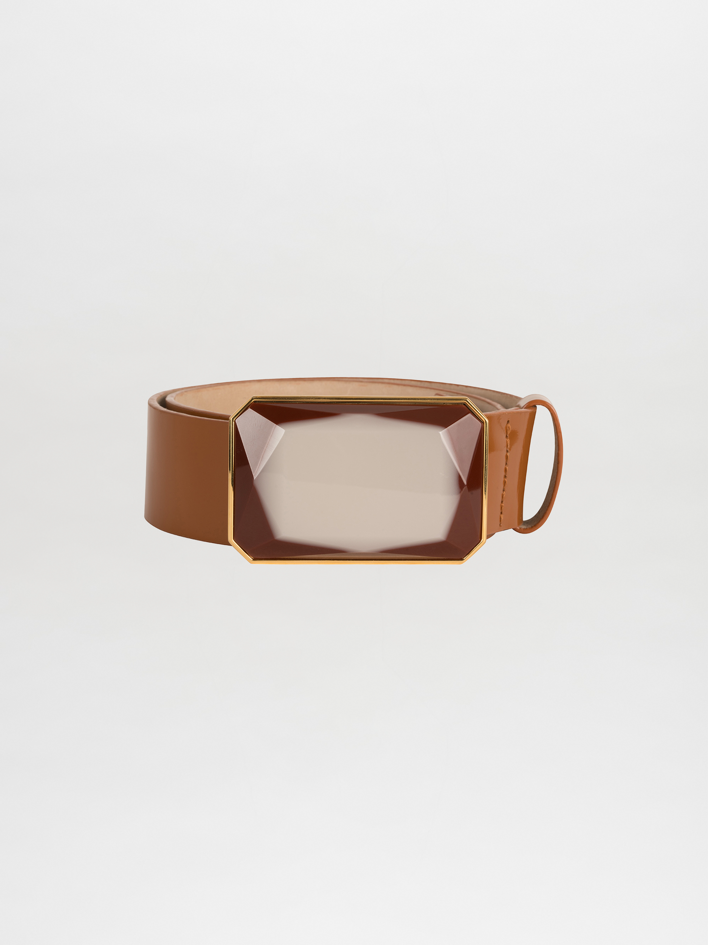 Introducing the Dora Belt Camel: a sophisticated brown leather belt adorned with a striking Italian resin gemstone buckle accented with gold trim. Its self-adjustable length guarantees the perfect fit, all beautifully displayed against a plain white background.