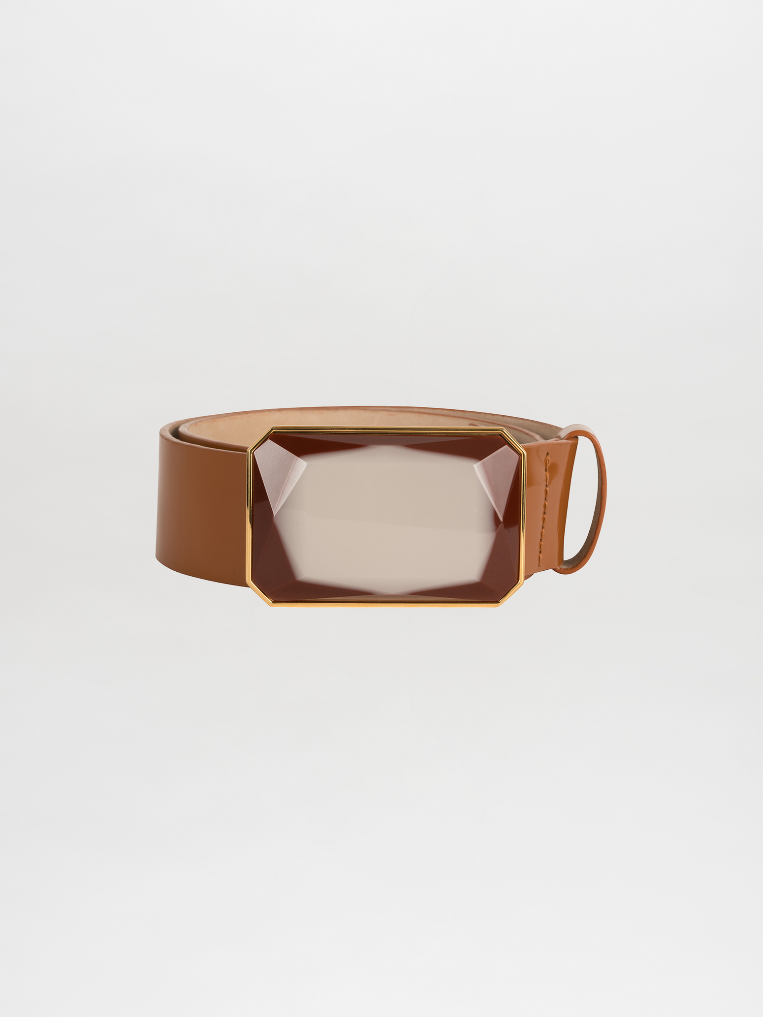 Introducing the Dora Belt Camel: a sophisticated brown leather belt adorned with a striking Italian resin gemstone buckle accented with gold trim. Its self-adjustable length guarantees the perfect fit, all beautifully displayed against a plain white background.