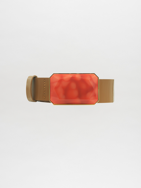 Introducing the Dora Belt Camel, a tan leather belt adorned with a large, rectangular faceted red gem buckle, perfect for adding a stylish and unique touch to your outfit. Please be aware that delivery times may vary depending on your location.