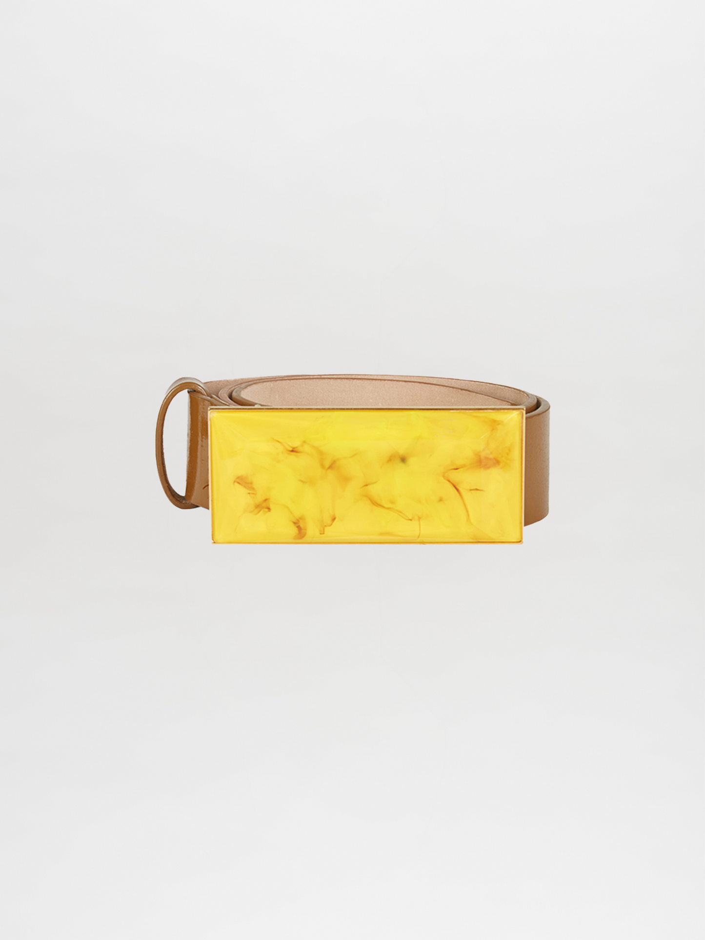 The Dora Belt Amber, featuring a brown strap and a large, rectangular yellow buckle, stands out against the white background, reminiscent of Silvia Tcherassi's bold designs.