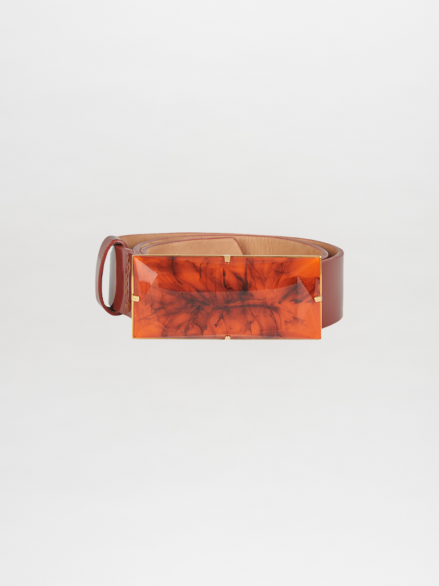 Introducing the Dora Belt Brick, a statement piece with a brown leather strap and a large, rectangular amber-colored buckle showcasing a captivating marbled pattern.