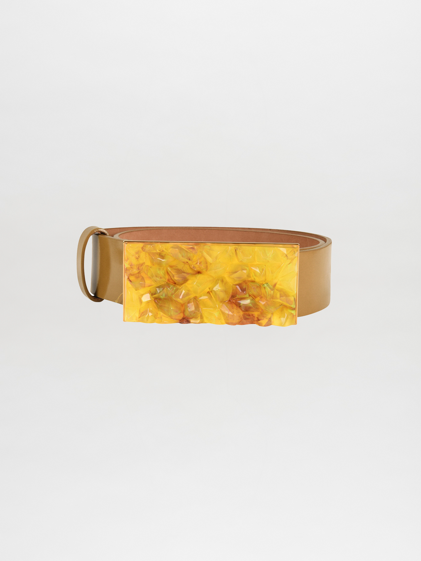 The Dora Belt Mustard in camel leather showcases a sleek, rolled-up design coupled with a large rectangular yellow buckle, reflecting the elegant style synonymous with Silvia Tcherassi.