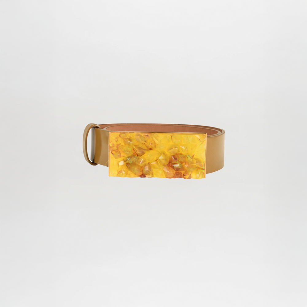 The Dora Belt Mustard is a tan leather statement belt featuring a large rectangular yellow marbled buckle, inspired by Silvia Tcherassi, shown on a plain white background.