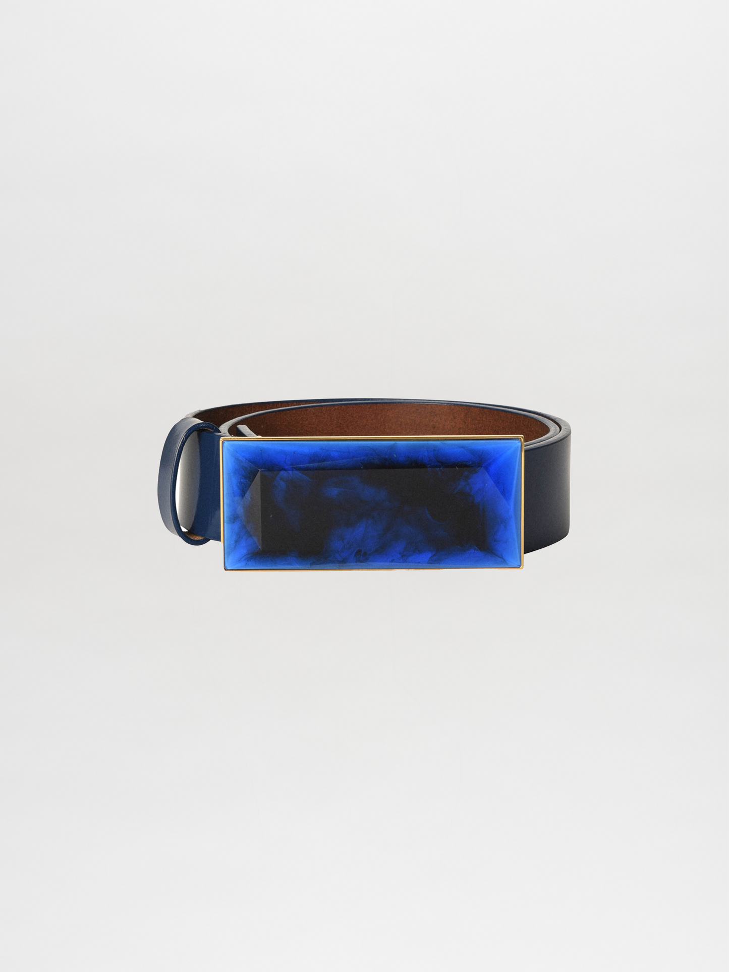 The Dora Belt Navy is a striking leather statement belt featuring a large rectangular buckle adorned with a blue and black marbled design.