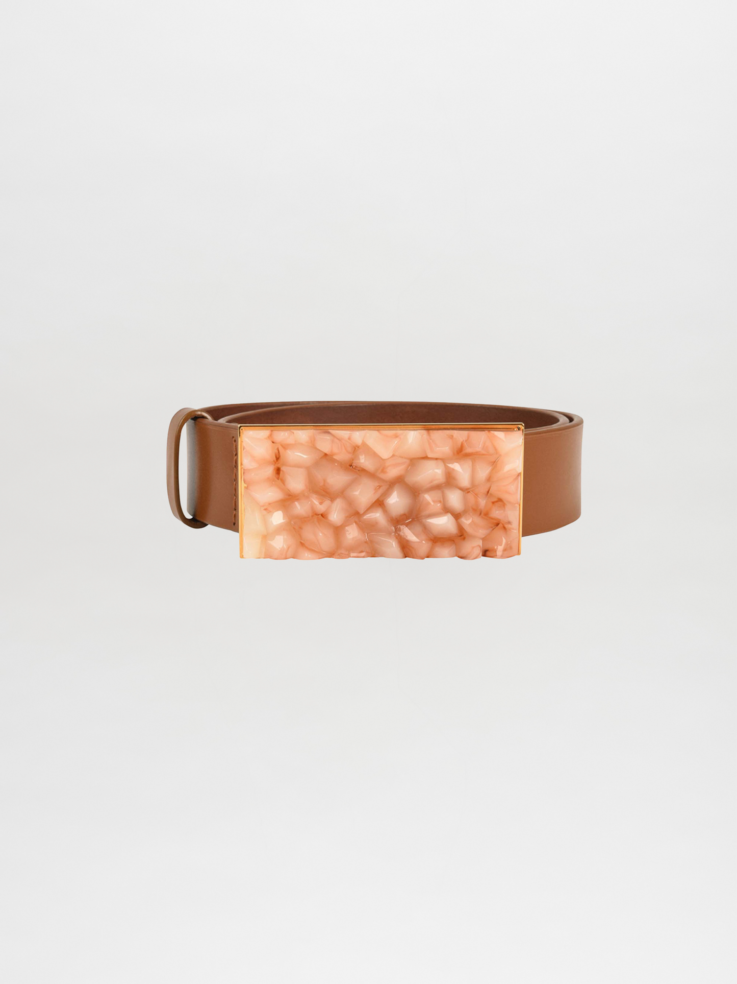 The Dora Belt Tan features a striking tan leather design with a large rectangular buckle that boasts a textured, amber-like finish, echoing the luxurious style reminiscent of Silvia Tcherassi.